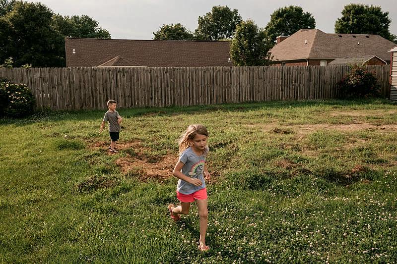 Ann plays in the backyard with a half-sibling.